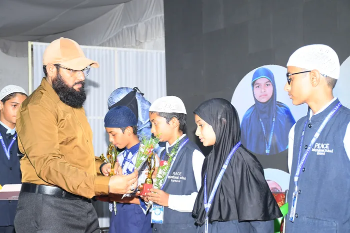 Students receiving trophies from the Chairman at a school prize ceremony
