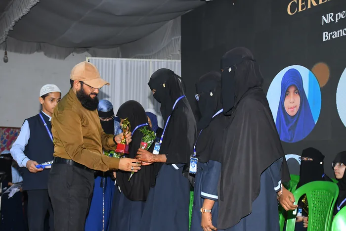 Students receiving prizes and bouquets on stage at the certificate ceremony