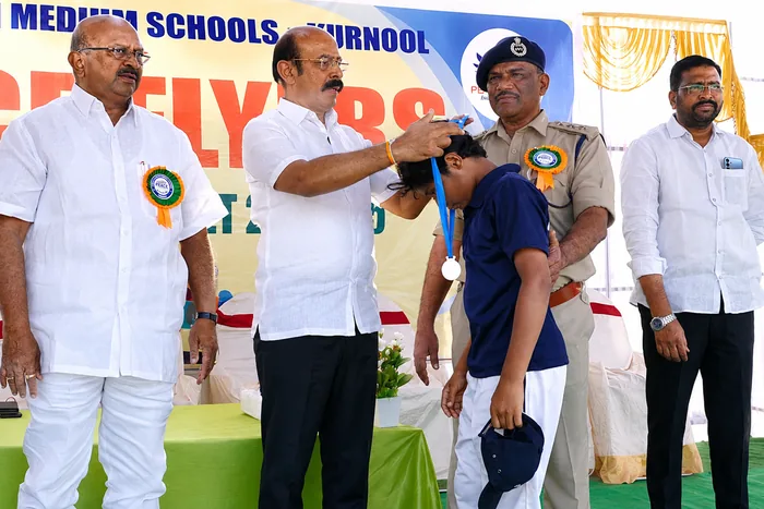 A student being presented with a medal by officials at a district sports event