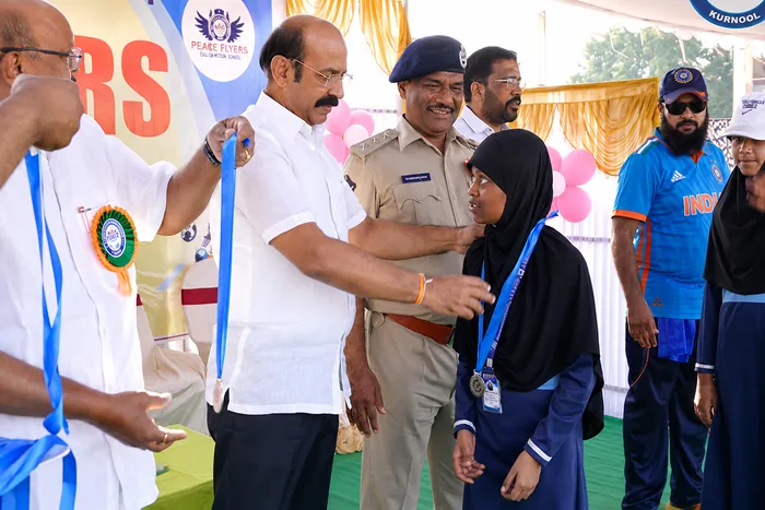 A student receiving a medal from officials at a district-level sports event