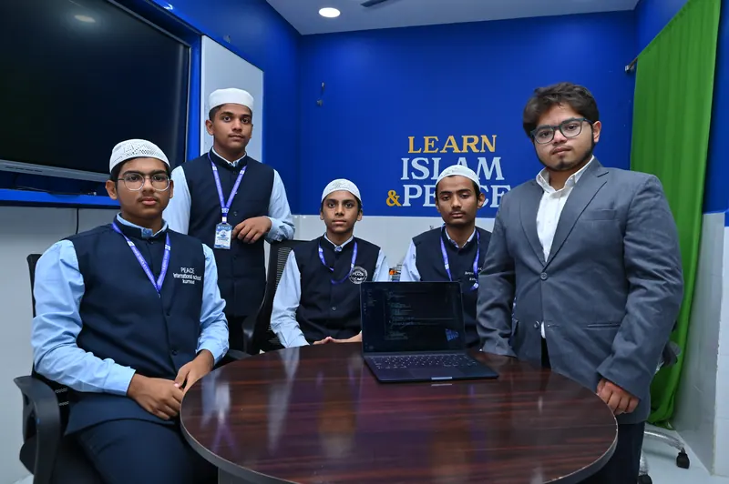 Students working with a teacher on laptops during an AI awareness session