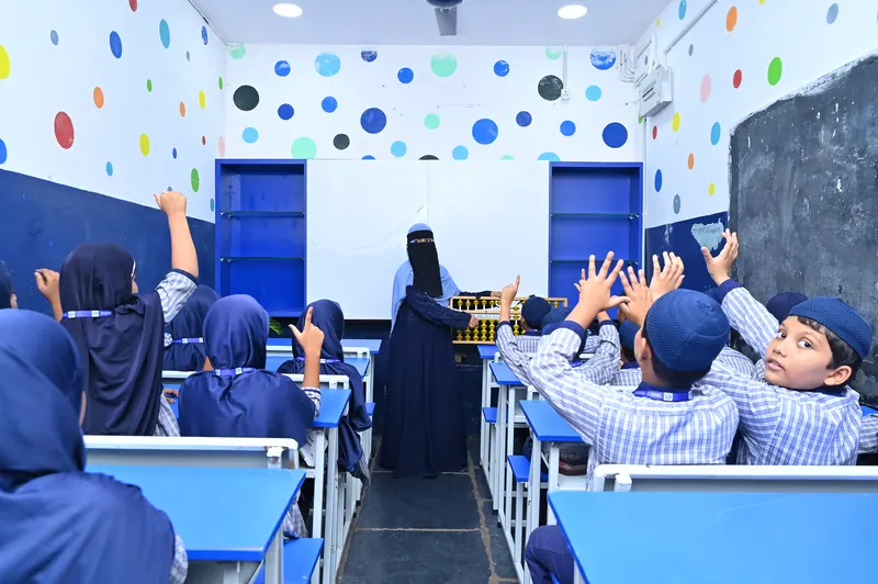 Primary students with their hands up during a mental mathematics lesson