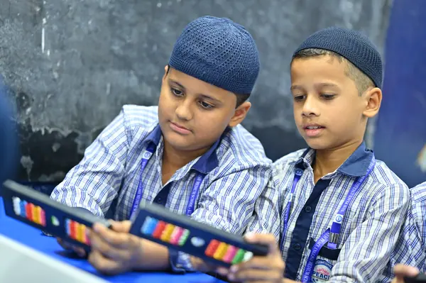 Two boys working side by side on their abacus frames — Peace English Medium School, Kurnool
