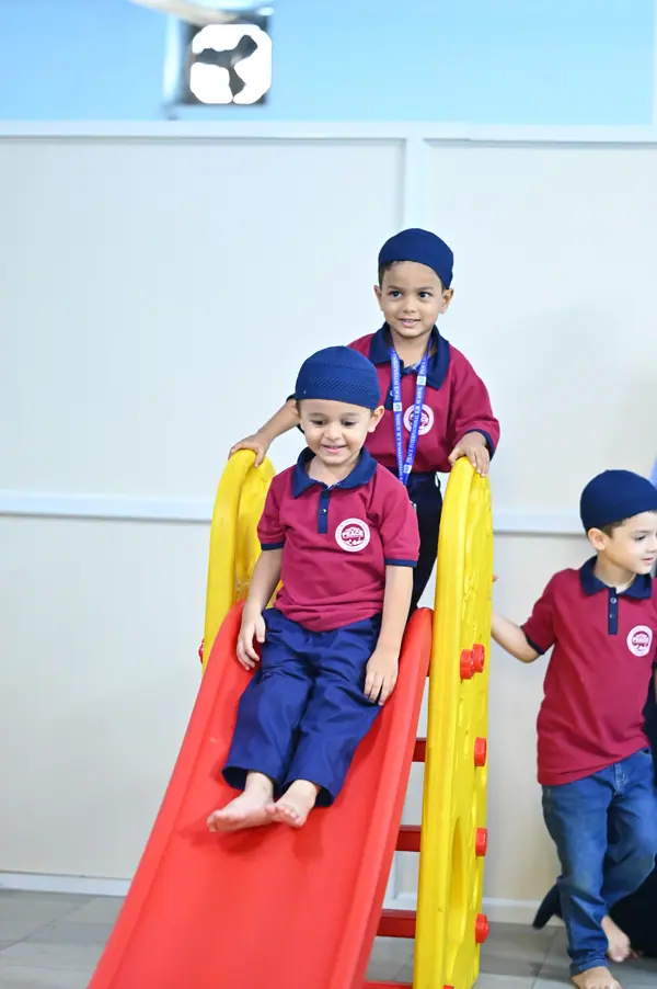 A small boy coming down the slide in the indoor play area — Peace English Medium School, Kurnool