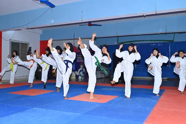 A karate class performing a kick in unison on the training floor — Peace English Medium School, Kurnool