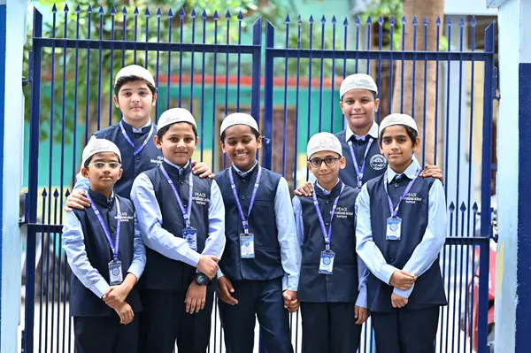 A class photographed together at the school gate — Peace English Medium School, Kurnool