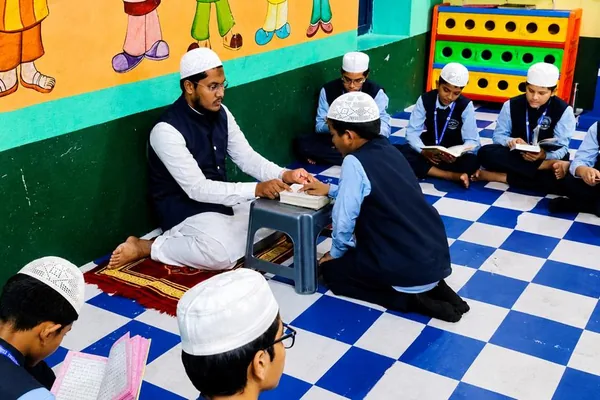 A Hifz teacher hearing a student recite while classmates revise around them