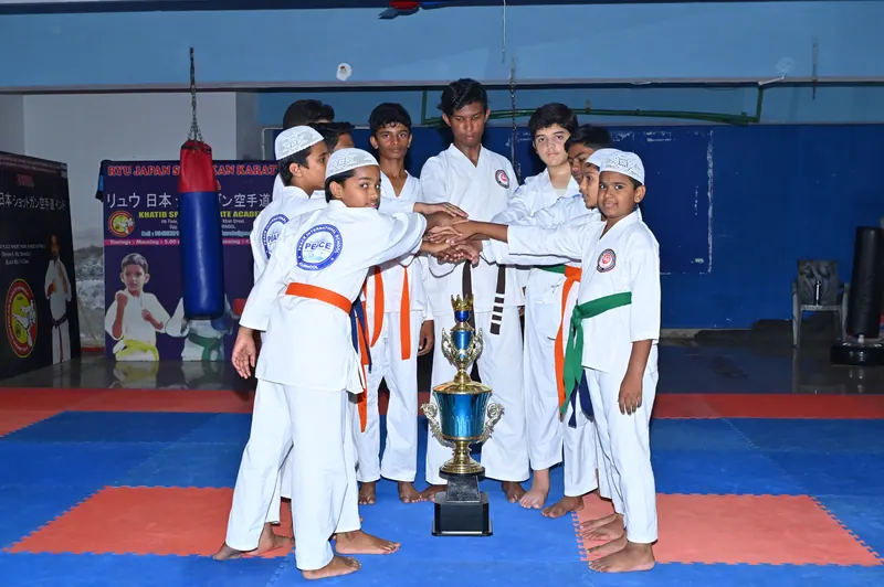 Peace School karate team holding a championship trophy after a tournament