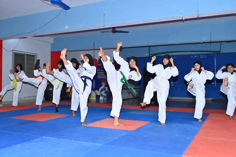 A student performing a high kick during karate training