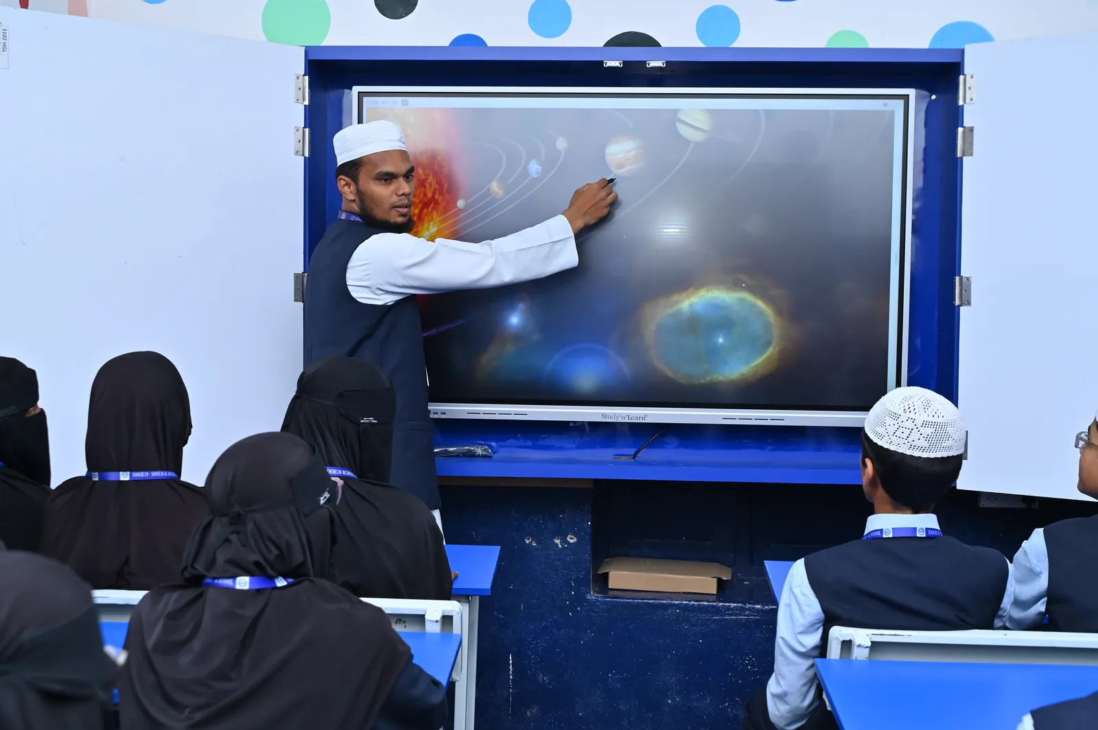 A teacher demonstrating an animated science lesson on the LED interactive panel