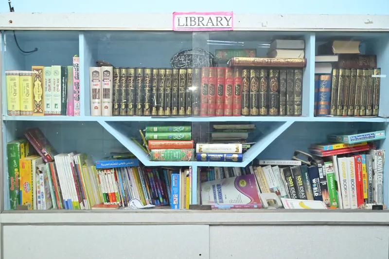 Library shelves filled with academic books, storybooks and reference material