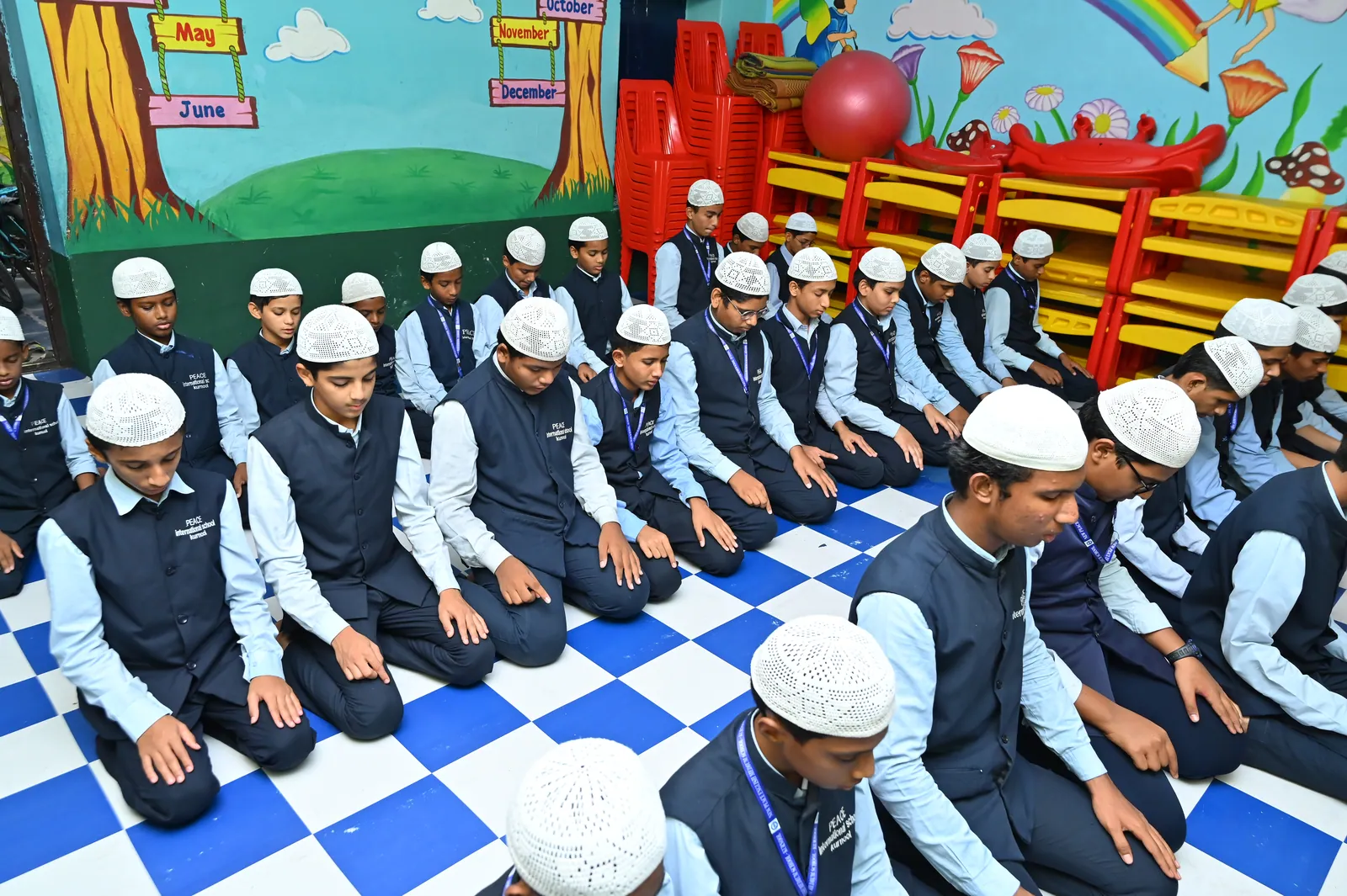Students with raised hands during supplication at a school gathering
