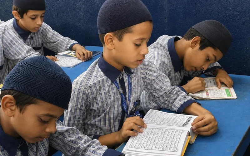Students reciting from the mushaf at their desks during a Tilawah session