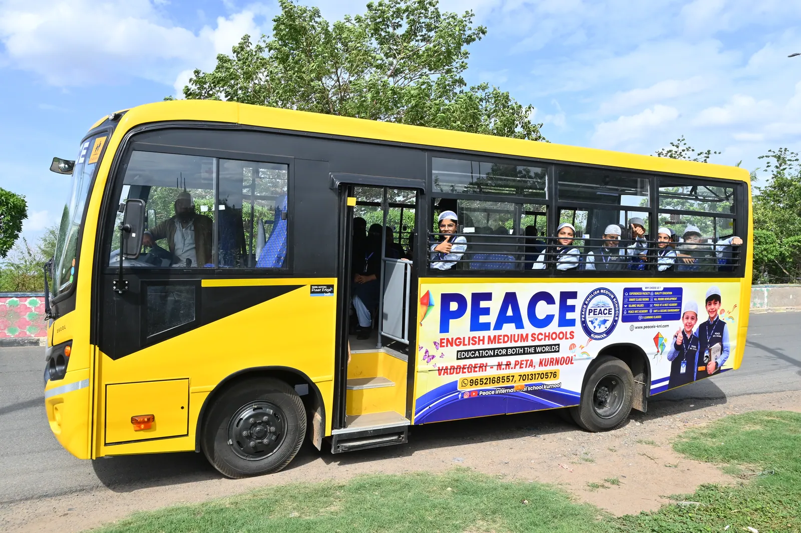 A yellow Peace English Medium School bus parked outside the campus