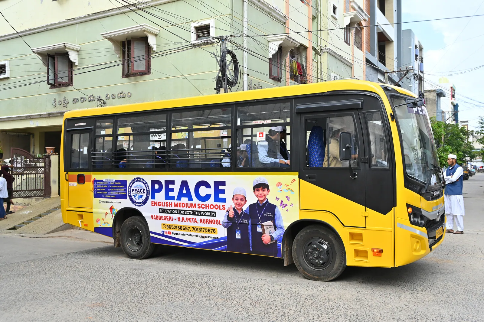 A Peace English Medium School bus on a street in Kurnool
