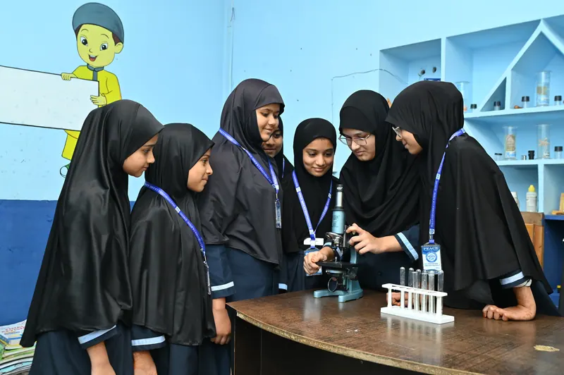 Students working with microscopes and glassware in the science laboratory