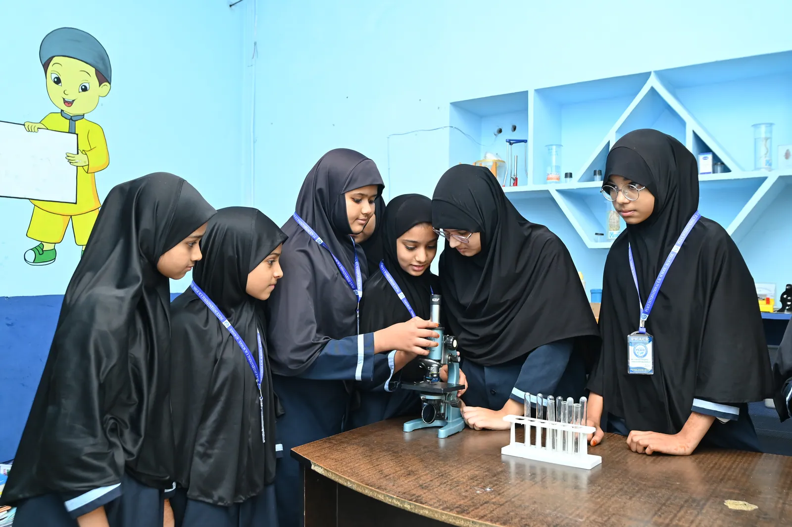 A student examining a specimen under a microscope in the science laboratory