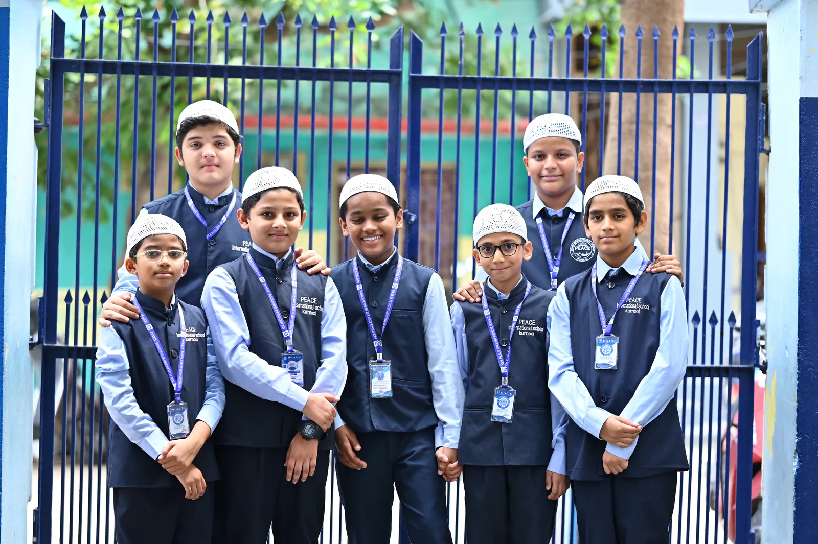 Students in full school uniform at the entrance to Peace English Medium School